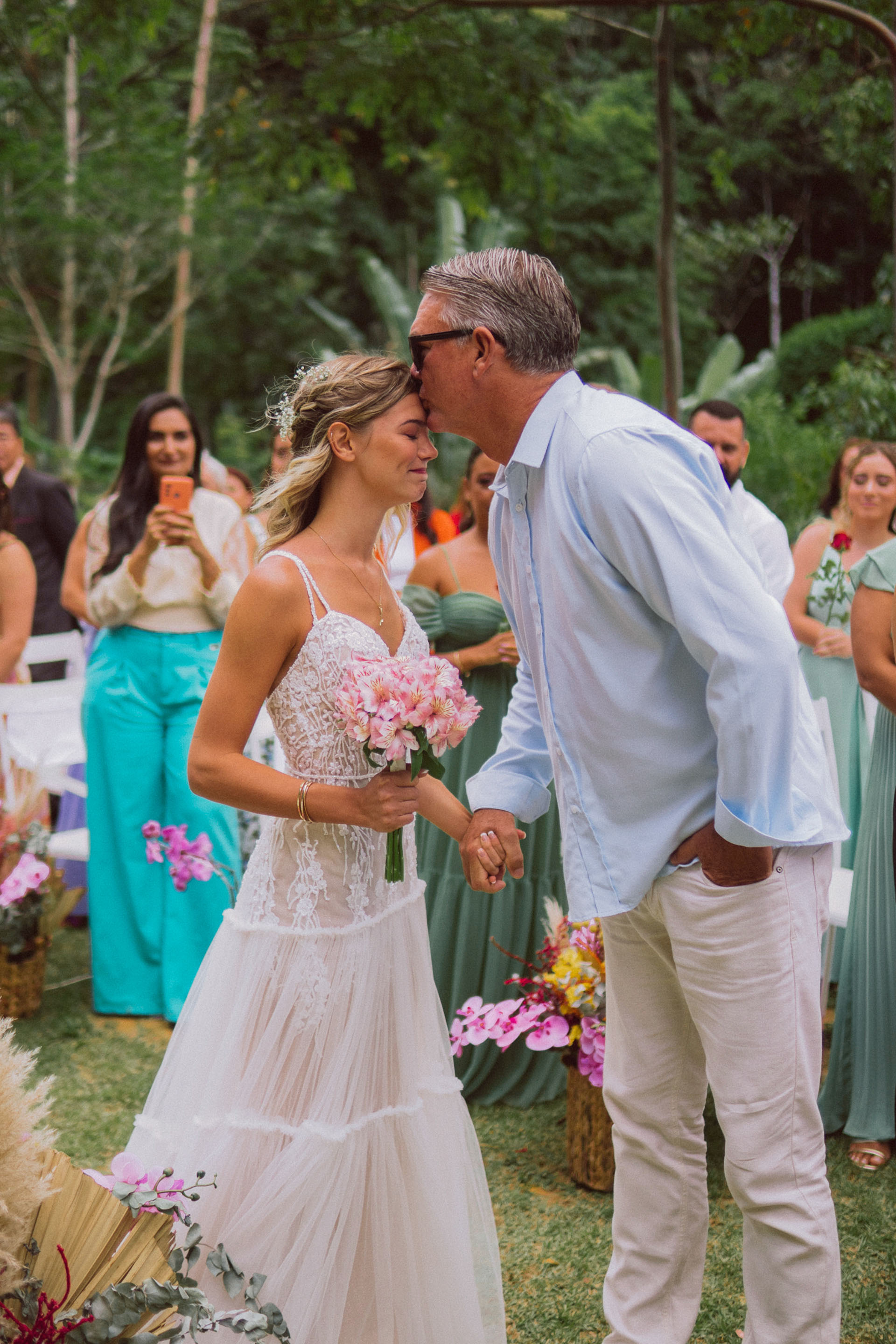 Casal Jade e Bodevan com pai durante cerimônia ao verde